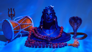 Lord Shiva statue with the third eye, with a damru and snake in the side, against a blue background